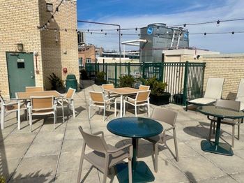 A patio with a table and chairs is set up on a rooftop. at 2400 Pennsylvania Avenue Apartments, Washington, DC,20037